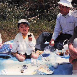 1988-05-02 マリンパーク（閉園）でおじいちゃん、おばあちゃんとピクニック<br>おにぎりを食べるCOTAと見守るおじいちゃん、おばあちゃん
