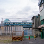 2012-01-15-11-38-24泉岳寺の再開発地区のビルの合間のガーター橋を走る京浜東北線